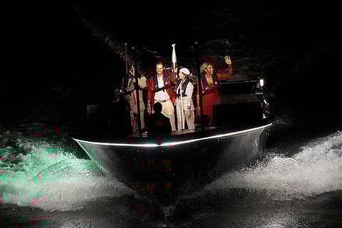 Rafael Nadal carries the Olympic flame flanked by Serena Williams